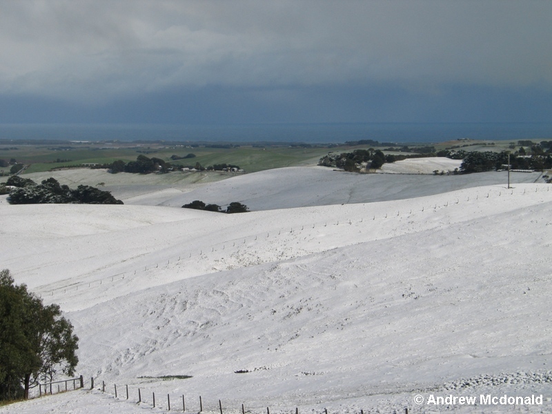 Ocean in the background with snow on the surrounding Bass hills.