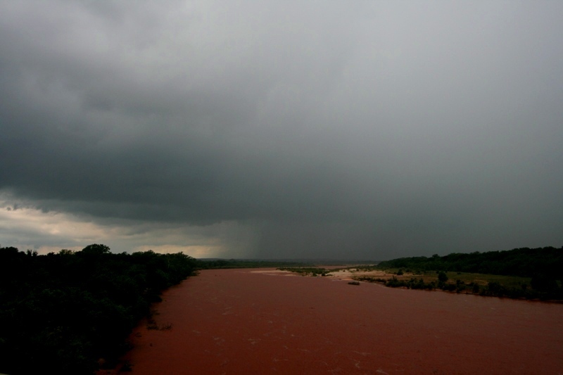 Pulse storm over the Red River (looking very red).  Oklahoma is on the right, Texas on the left.  Taken from near Courtney, OK.