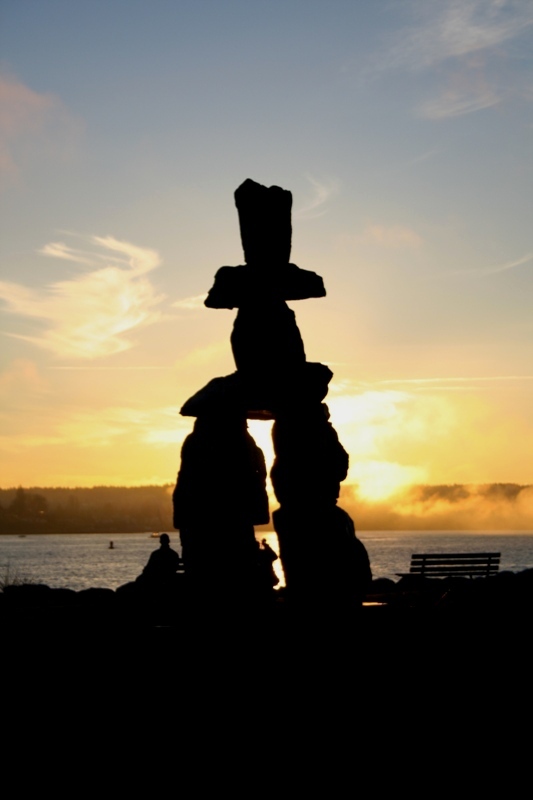 An Inukshuk overlooks the setting sun at English Bay 